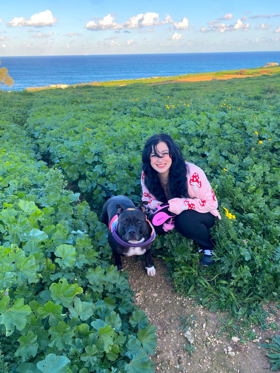A nurse walking a dog by the sea